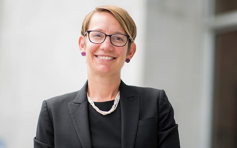 Female assistant district attorney standing on steps of Hall of Justice in San Francisco.