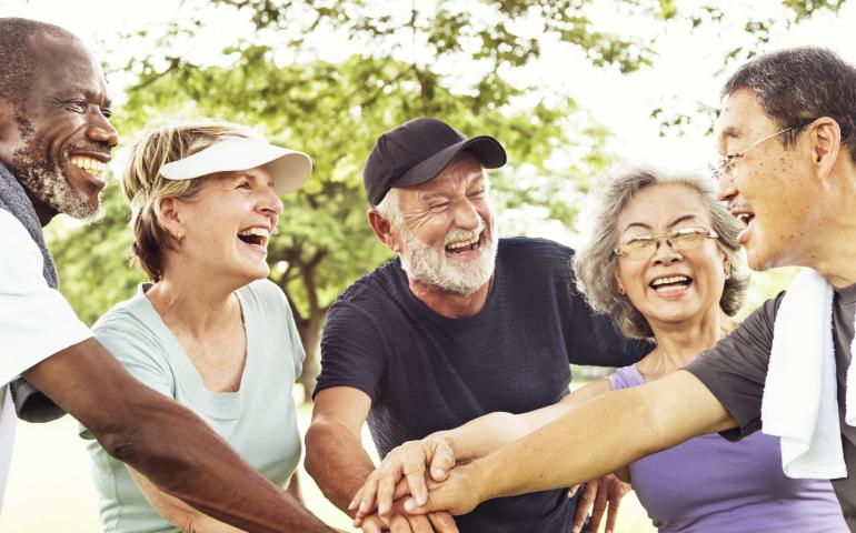 elderly group hand in cheers