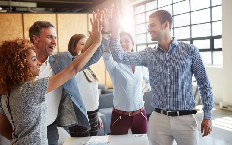 group of coworkers giving high fives