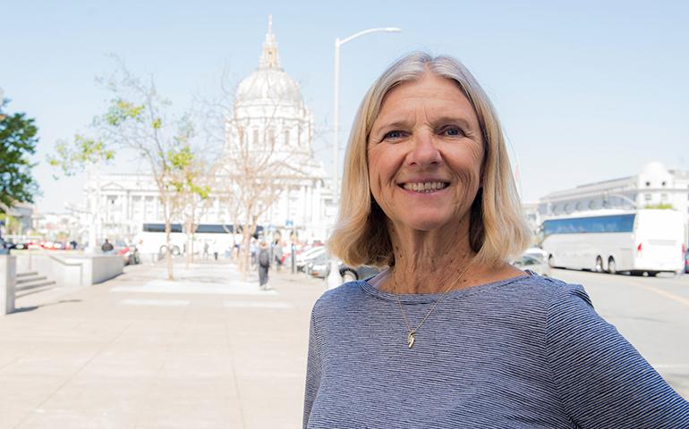 Retired female City and County of San Francisco employee standing outside with City Hall in background.
