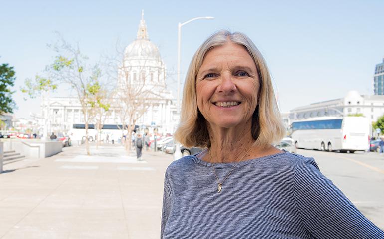 Retired female City & County of San Francisco employee standing in Civic Center with City Hall in the background.