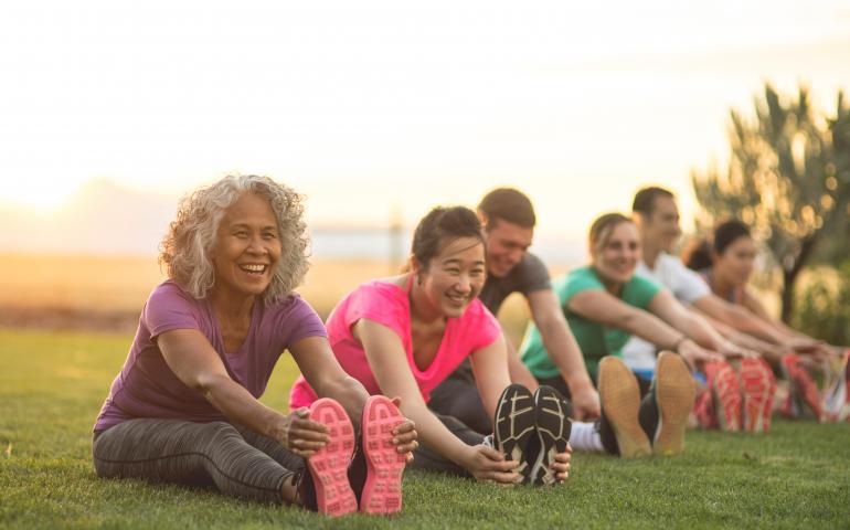 group siting on grass stretching