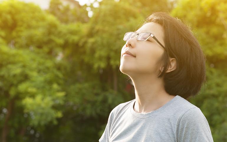 woman outside taking in a deep breath