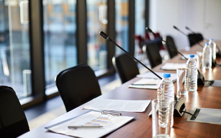 Empty board room with chairs and microphones.