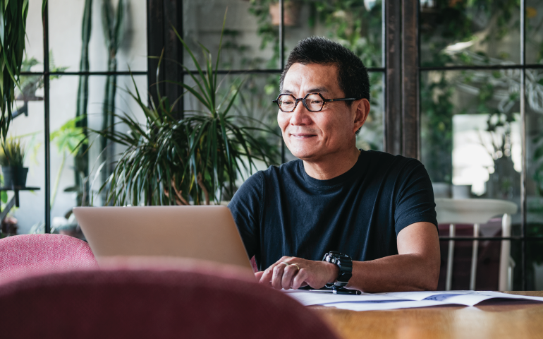 Asian man looking at computer