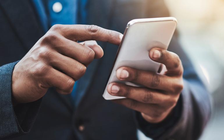 A Black Sharp Dressed Man Holding Smartphone