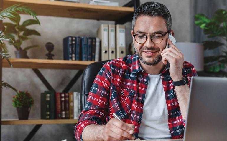 Man talking on cell phone taking notes