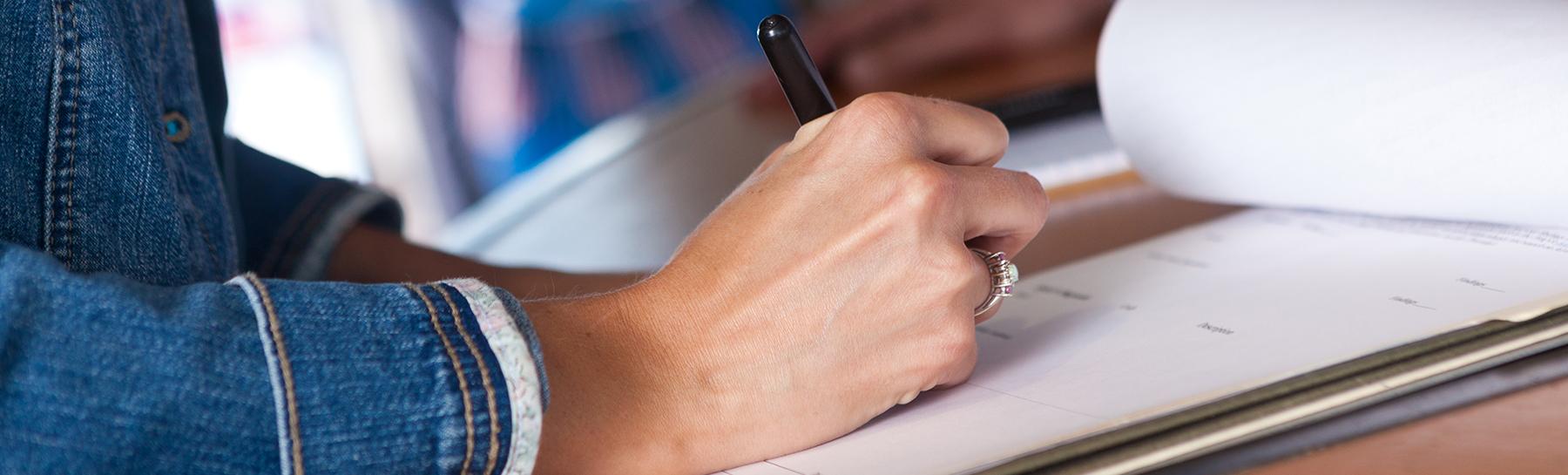 Image of hand writing on a notepad.