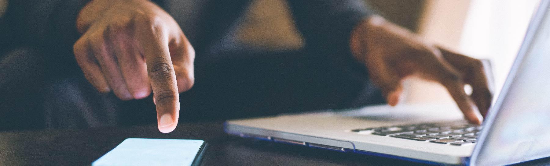 Image of hands typing on a laptop computer.
