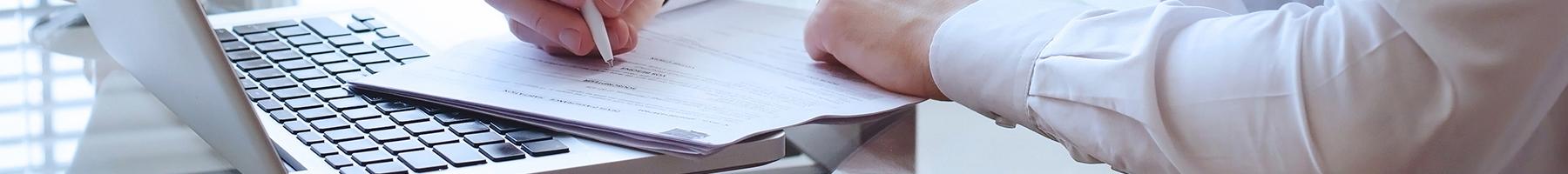 Image of man writing at a desk.