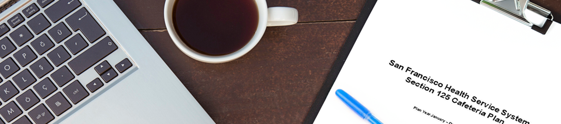 Laptop, coffee cup, and SFHSS Document on the table