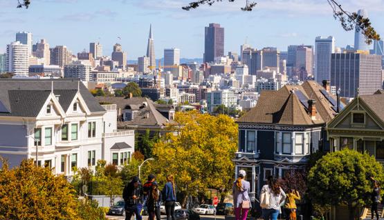 Image of downtown San Francisco on top of the hill near the Painted Ladies with trees turning in fall colors. 