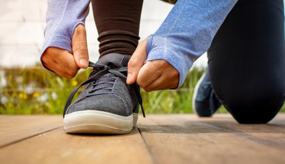 A guy is tying up his sneakers for physical activity